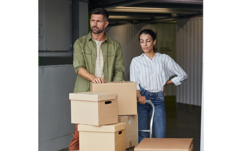couple with boxes on cart at storage facility