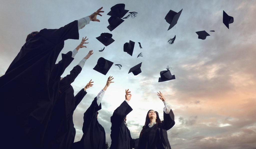 graduates throwing their hats up in the sky