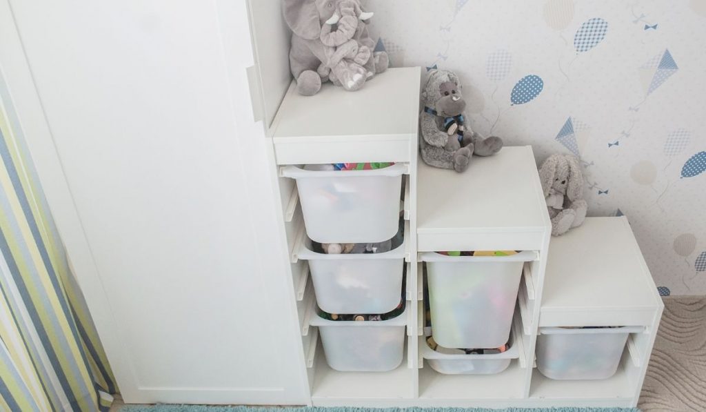 white vertical cabinet beside the toy storage drawers