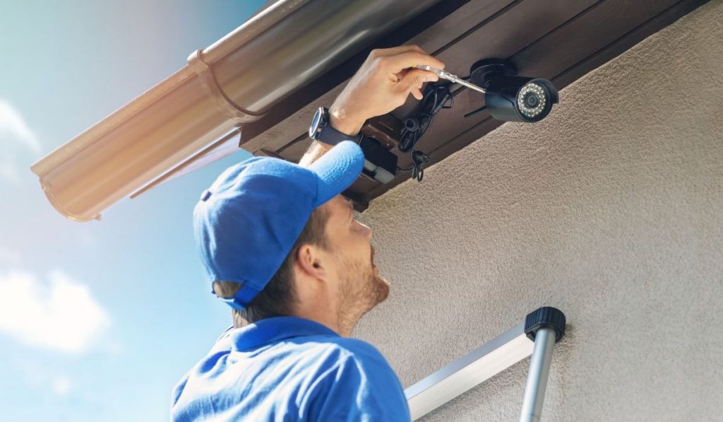 man installing a security camera at a storage facility