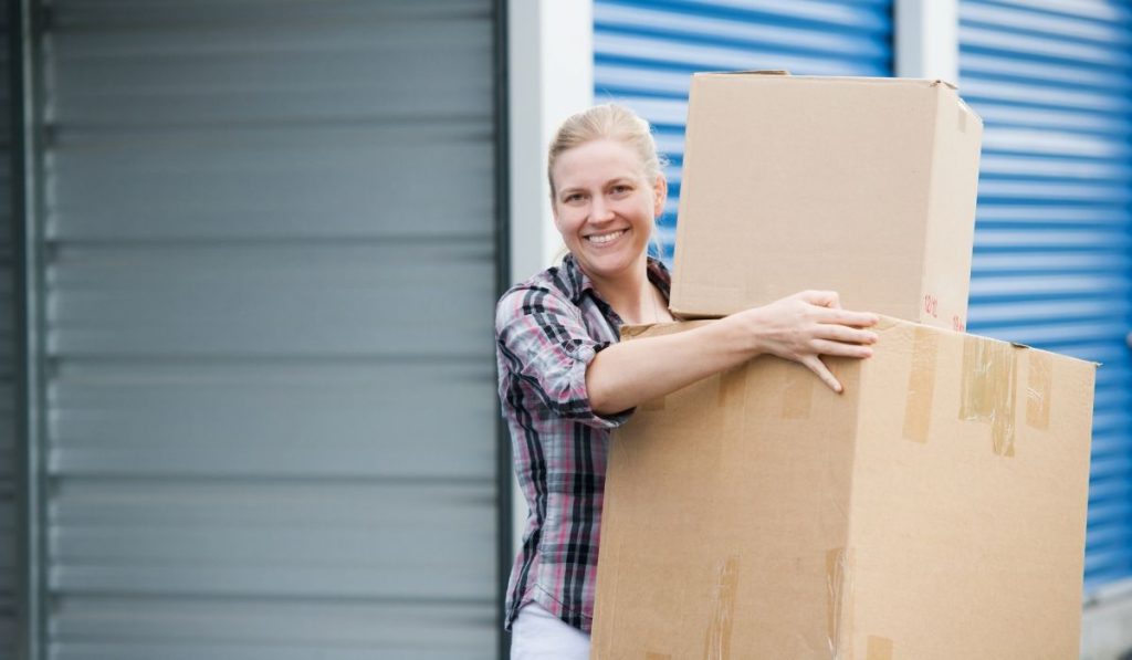 woman holding boxes renting a storage unit for the first time